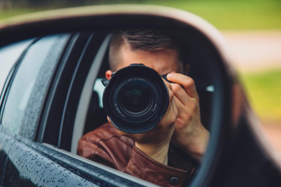 Surveillance investigator taking a photo